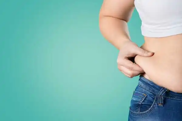 Image of woman pinching her love handles to show weight gain Rushden